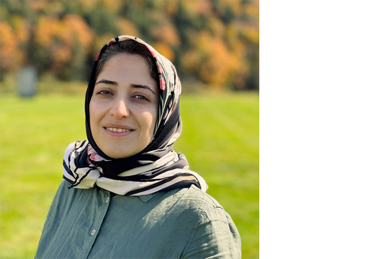headshot of a person with green grass in the background